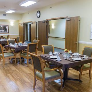 An empty dining room with tables set and ready for guests.