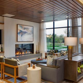 A modern living room featuring a cozy fireplace, stylish furniture, and large windows with natural light.