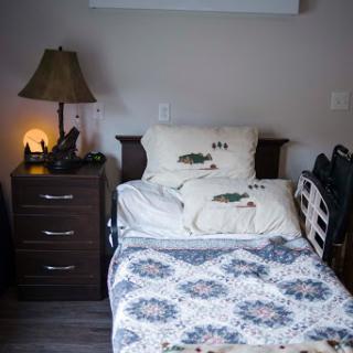 A cozy bedroom featuring a neatly made bed with decorative pillows, a stylish nightstand, and a warm lamp.