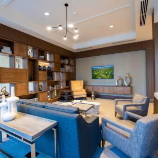 A modern living room featuring sleek furniture, built-in bookshelves, and stylish lighting.