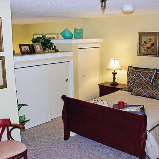 A cozy bedroom with a sleigh bed, bedside lamp, and decorative elements.