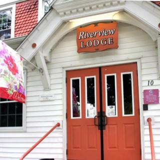 Entrance of a restaurant with an orange sign and double doors.