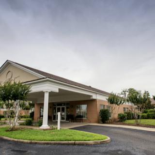 A welcoming entrance to a hospitality venue, set against a cloudy sky.