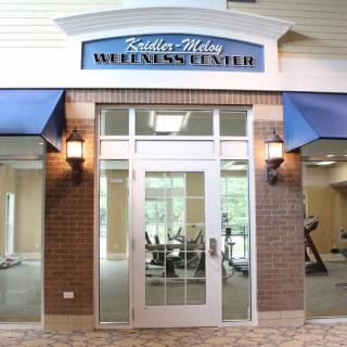 The entrance of a wellness center with fitness equipment visible inside.
