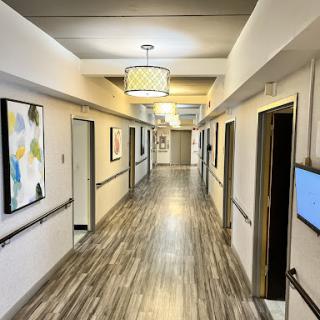 A bright and modern hallway featuring artwork on the walls and elegant lighting.