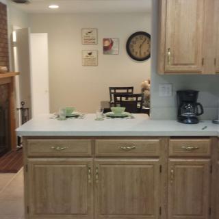 A cozy kitchen with a wooden countertop and dining area in the background.