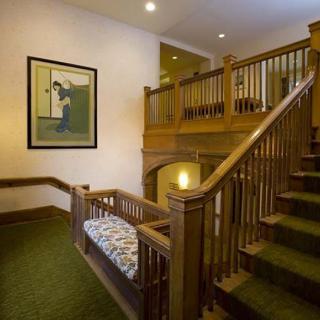 A cozy interior with a wooden staircase, carpeted steps, and artwork on the wall.