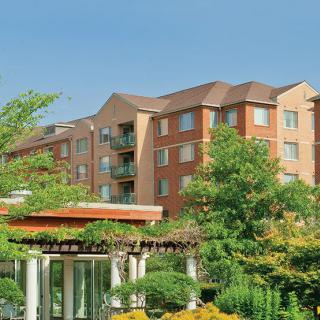 A residential apartment complex surrounded by lush greenery and trees.