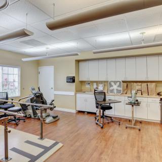 A physical therapy room equipped with exercise machines and supplies, designed for rehabilitation and healthcare activities.