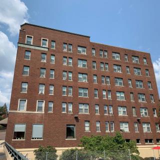 A multi-story brick apartment building under a clear blue sky.