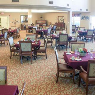 An empty dining area with neatly arranged tables and chairs, ready for guests.