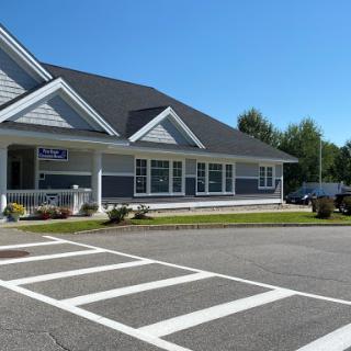 A modern building surrounded by well-maintained landscaping under a clear blue sky.