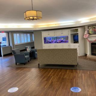 A spacious and inviting lobby area featuring comfortable seating, an aquarium, and warm lighting.
