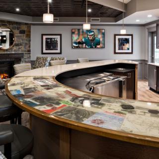 A modern bar interior featuring a curved counter with seating and decorative artwork on the walls.