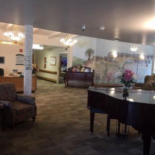 A cozy lobby interior featuring a grand piano and comfortable seating.