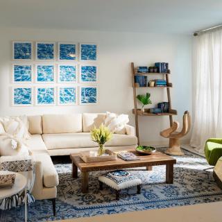 A cozy living room with a cream sofa, wooden coffee table, and vibrant wall art.