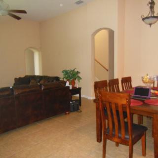 A spacious living and dining area featuring comfortable seating and a wooden dining set.