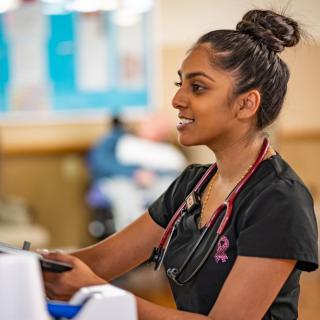 A nurse in a medical setting working attentively.