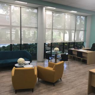 A modern office space featuring comfortable seating and large windows allowing plenty of natural light.