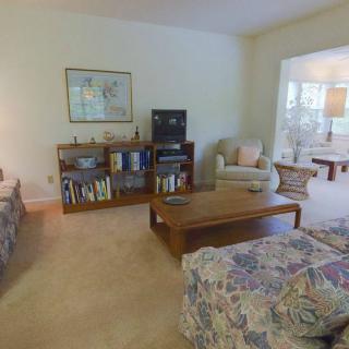 A cozy living room with sofas, a coffee table, and a bookshelf.