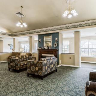 A spacious living room with comfortable seating, a central fireplace, and large windows allowing natural light.