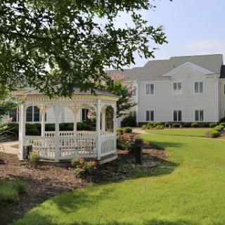 A serene garden featuring a charming gazebo next to a lovely home.