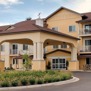 A well-maintained residential building with a covered entrance and landscaped surroundings.