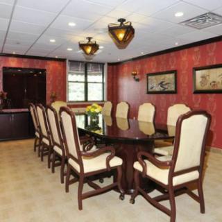 A well-furnished conference room with a long table and elegant chairs.