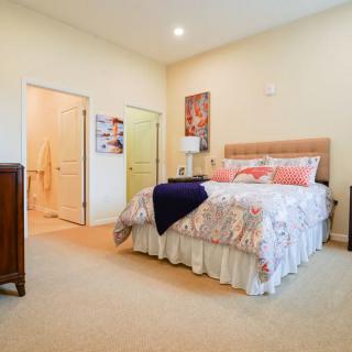 A cozy bedroom with a neatly made bed, soft lighting, and warm decor.