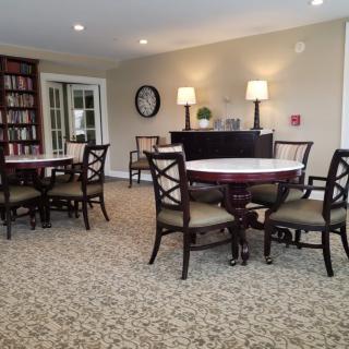 Cozy library seating area with round tables and bookshelves.