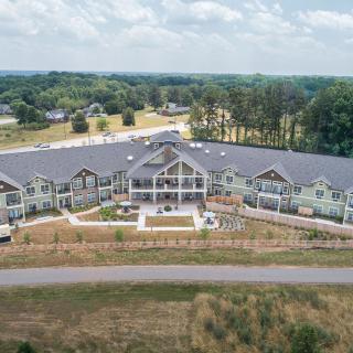 An aerial view of a modern building situated in a scenic landscape.