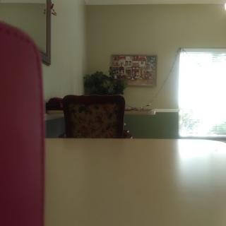 A cozy and simple interior view featuring a table, chair, and softly lit window.