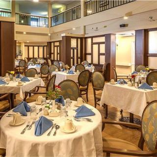An elegant restaurant dining room with formally set tables prepared for guests.
