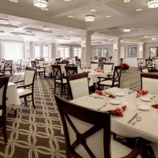 An elegantly set dining room with neatly arranged tables and chairs.