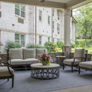 A serene outdoor patio featuring comfortable seating and a decorative table, perfect for relaxation.