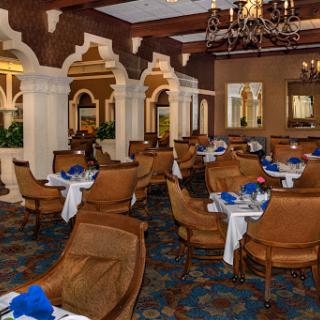 An elegant dining area featuring Arabian architectural elements, complete with stylish furniture and a blue and white color scheme.