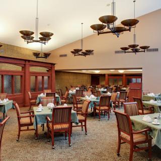 A spacious and elegantly designed dining area featuring wooden furniture and unique lighting fixtures.