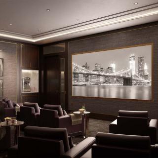 A luxurious home theater room with comfortable seating and a large projector screen displaying a black and white cityscape.