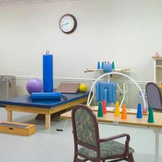 A physical therapy room equipped with various exercise tools and apparatus.