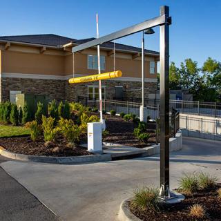 A drive-thru lane with a height restriction bar near a restaurant building.