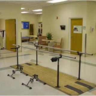 A physical therapy room equipped with parallel bars in a medical facility.