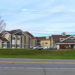 A view of a hotel complex featuring multiple buildings and well-maintained lawns.