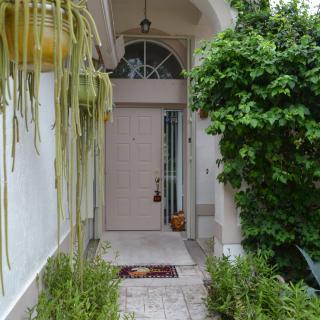 A welcoming front entrance surrounded by lush greenery and architectural details.
