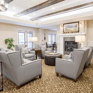 A cozy and modern living room with comfortable seating around a fireplace.