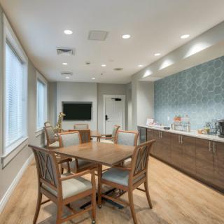 A modern meeting room with a large conference table, comfortable chairs, and ample natural light.