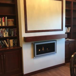 A modern living room featuring a stylish fireplace and built-in bookshelves.