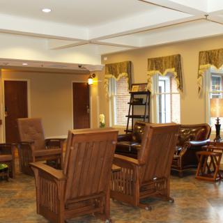 A cozy living room with wooden furniture and large windows.