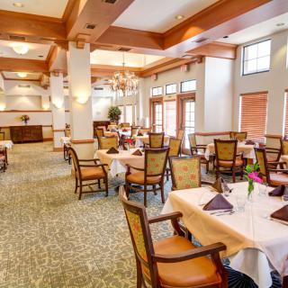 An elegant restaurant dining room with neatly arranged tables and chairs.