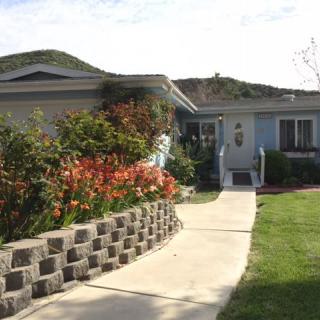 A charming house with a beautifully landscaped garden and pathway.