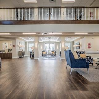 A spacious and modern lobby with wood flooring and comfortable seating areas.
